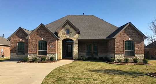 A modern home with a durable asphalt shingle roof, designed to withstand Oklahoma’s extreme weather conditions, including storms, hail, and heat.