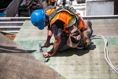 Roofer fixing leaky spots on roof before adding shingles