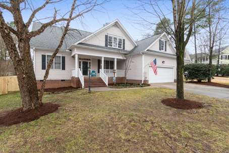 A well-maintained suburban home with a neatly trimmed lawn, American flag on the porch, and a gray shingle roof showcasing curb appeal and residential roofing quality.